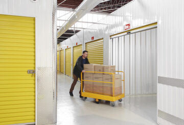 Customer of Wilson Storage, transporting goods on a pallet jack to a roller door secure, indoor storage unit.