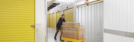 Customer of Wilson Storage, transporting goods on a pallet jack to a roller door secure, indoor storage unit.